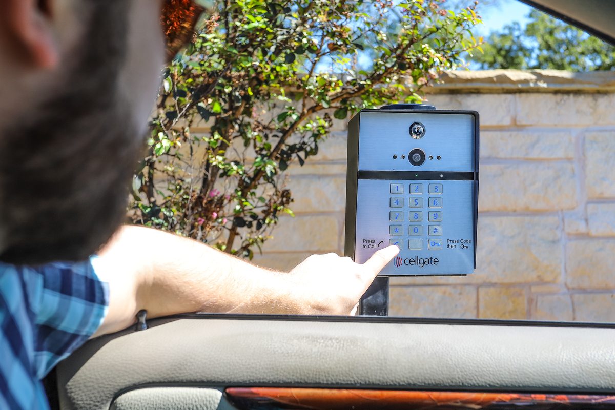 Driver entering a code on a CellGate Watchman W410 gate entry unit, installed by Ark Security in Tampa Bay