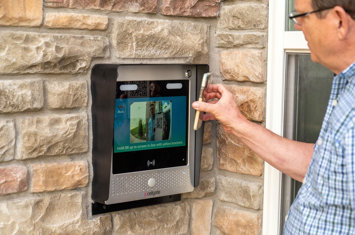 Visitor scanning a QR code visitor pass at a CellGate Watchman WXL to enter a gated community