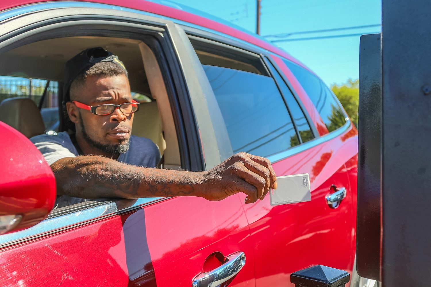 Driver presenting an access keycard at a gated entry